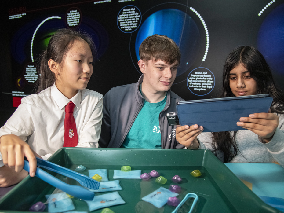 Group of 3 people at Glasgow Science Centre taking part in an activity